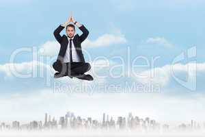 Composite image of businessman sitting in lotus pose with hands