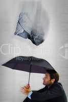 Composite image of businessman holding umbrella sitting on the f