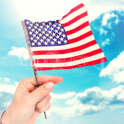 Composite image of hand waving american flag