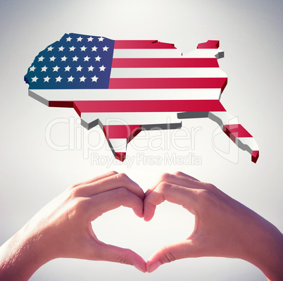 Composite image of hands making heart shape on the beach