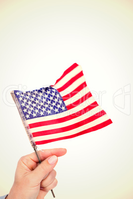 Composite image of hand waving american flag