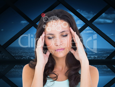 Composite image of pretty brunette with a headache