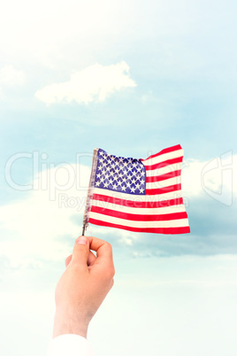 Composite image of hand waving american flag