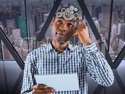 Composite image of young businessman thinking and holding tablet