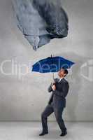 Composite image of businessman sheltering under blue umbrella