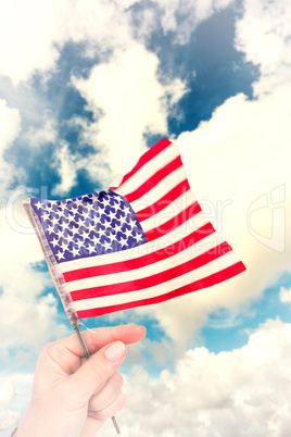 Composite image of hand waving american flag