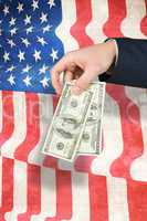 Composite image of hand holding hundred dollar bills