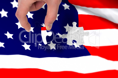 Composite image of hand holding jigsaw piece