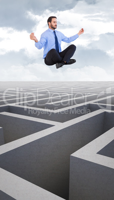 Composite image of businessman in suit sitting in lotus pose