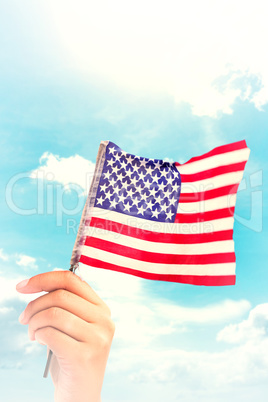 Composite image of hand waving american flag