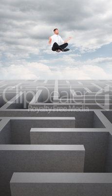 Composite image of businessman meditating in lotus pose