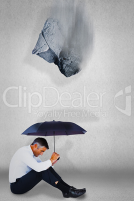 Composite image of smiling businessman under yellow umbrella