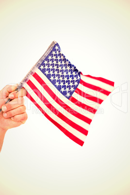 Composite image of hand waving american flag