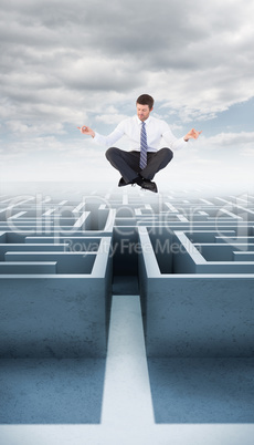 Composite image of businessman in suit sitting in lotus pose