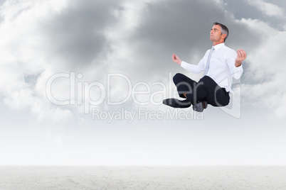 Composite image of peaceful businessman sitting in lotus pose