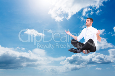 Composite image of businessman meditating in lotus pose