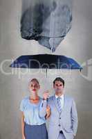 Composite image of business people holding a black umbrella