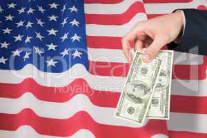 Composite image of hand holding hundred dollar bills