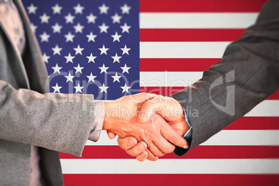 Composite image of two people having a handshake in an office Composite image of two people having a handshake in an office
