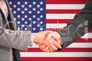 Composite image of two people having a handshake in an office