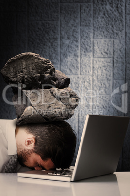 Composite image of exhausted businessman sleeping head on laptop