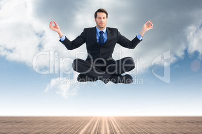 Composite image of calm businessman sitting in lotus pose