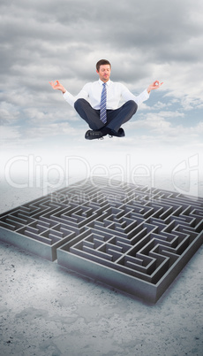 Composite image of businessman meditating in lotus pose