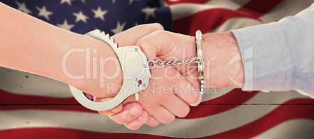 Composite image of handcuffed business people shaking hands