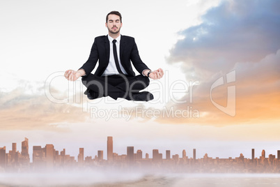 Composite image of peaceful businessman sitting in lotus pose re