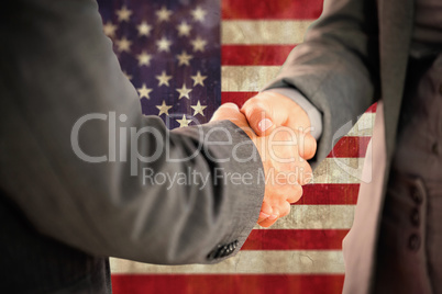 Composite image of business people shaking hands close up