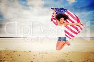 Composite image of pretty girl wrapped in american flag jumping