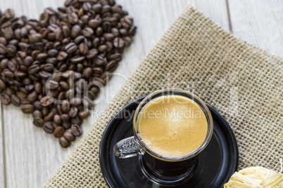 Strong mug of espresso coffee with coffee beans