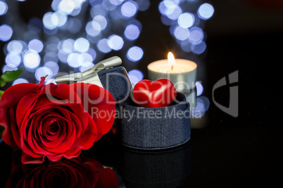 Rose, Candle and Jewelry Present Gift Box on Table