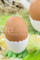 Two Boiled Eggs in Egg Cups Next to Basket of Eggs