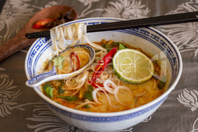 Bowl of spicy Asian soup with noodles