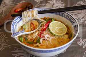 Bowl of spicy Asian soup with noodles