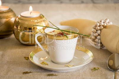 Cup of creamy potato soup and serrano ham chips for Christmas dinner