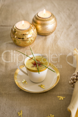 Cup of creamy potato soup and serrano ham chips for Christmas dinner