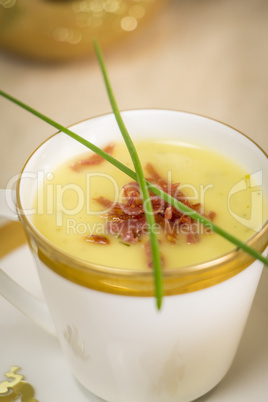 Cup of creamy potato soup and serrano ham chips for Christmas dinner