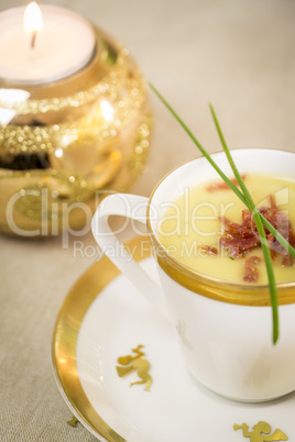 Cup of creamy potato soup and serrano ham chips for Christmas dinner