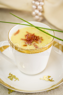 Cup of creamy potato soup and serrano ham chips for Christmas dinner
