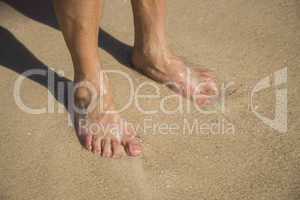 Female feet in sparkling sunlit water
