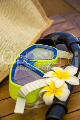 A snorkel and goggles lying on a wooden bench