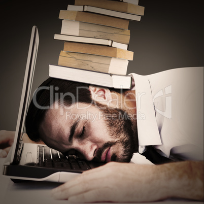 Composite image of businessman resting head on laptop keyboard