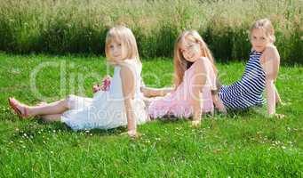 girls sitting on green grass