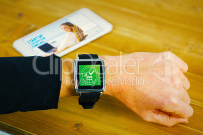 Composite image of businesswoman with smart watch on wrist