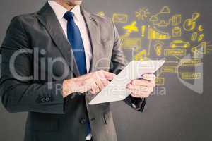 Composite image of businessman using his tablet pc