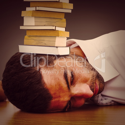 Composite image of tired businessman resting on his desk