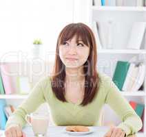 Asian girl eating breakfast and thinking