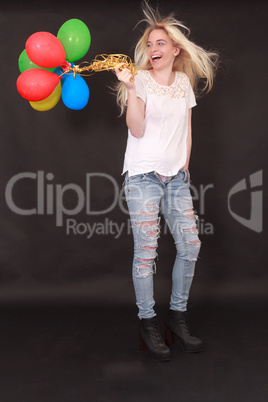 Junge lachende Frau mit Luftballone in der Hand